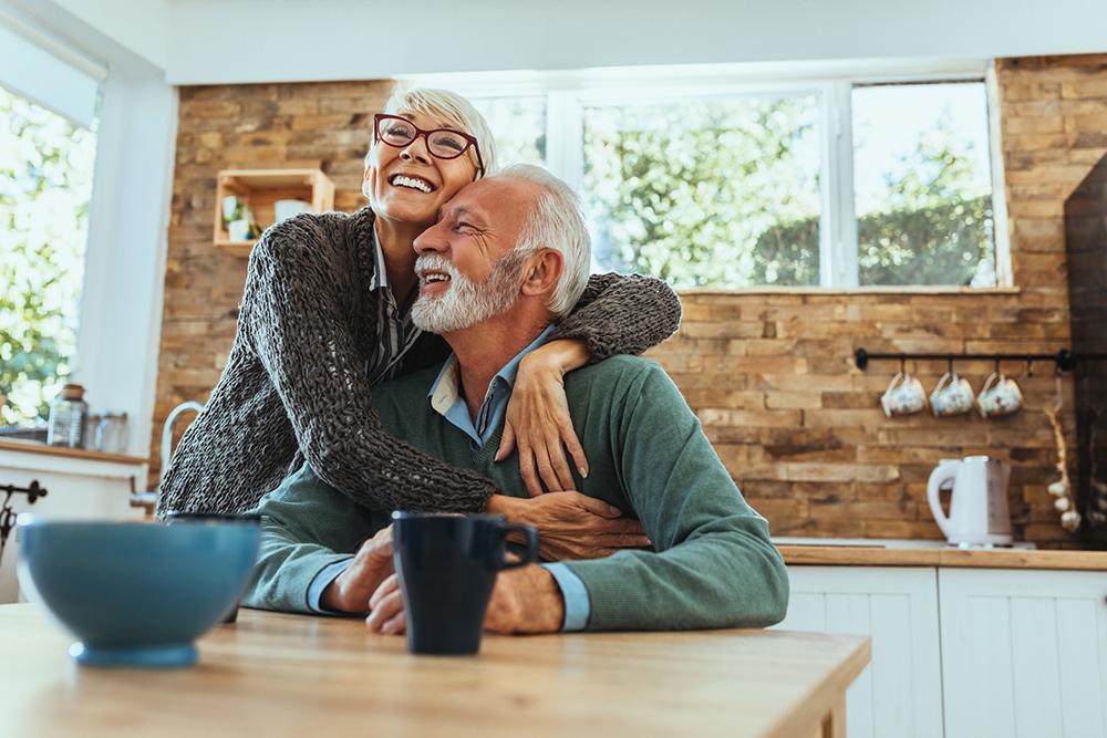 senior couple hugging in kitchen