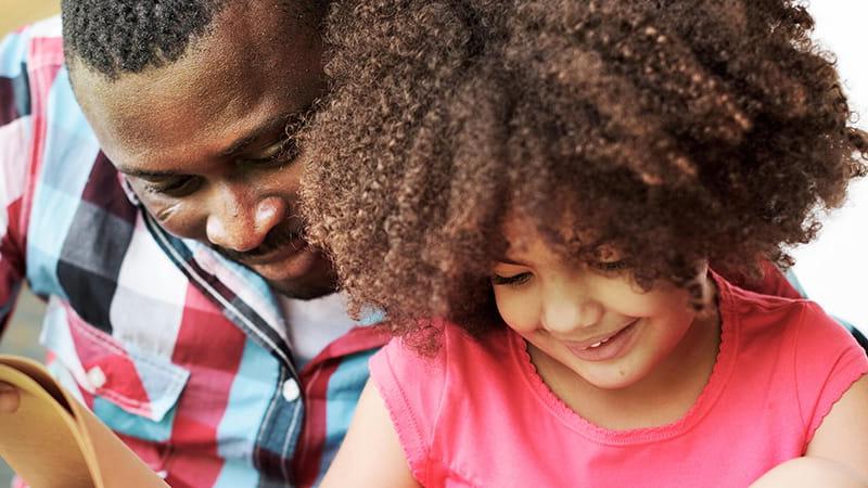 father and daughter reading book